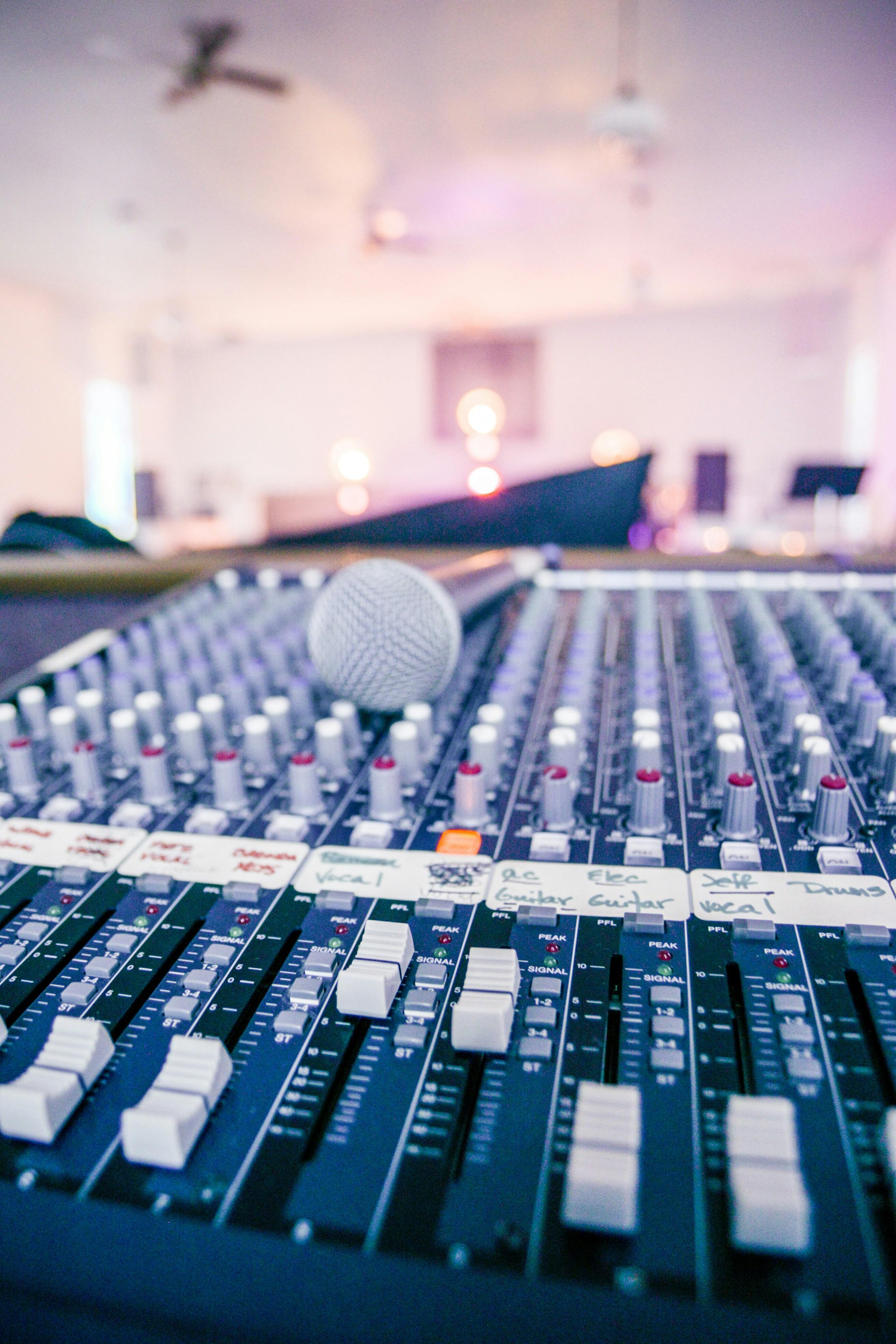 Microphone resting on an audio mixing console